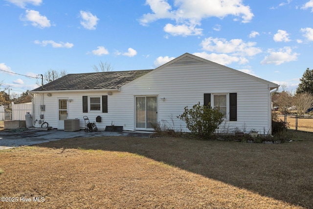 rear view of property featuring central AC unit, fence, a lawn, and a patio