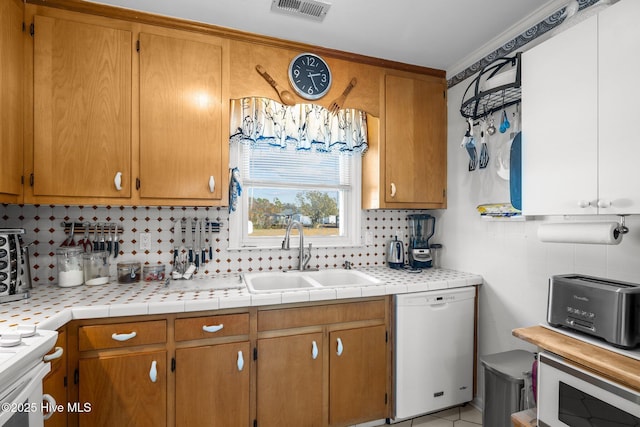 kitchen with white appliances, visible vents, light countertops, and a sink