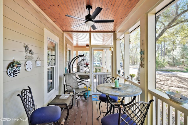 sunroom / solarium with a ceiling fan and wooden ceiling