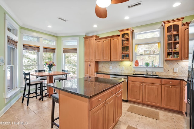 kitchen featuring dishwasher, a sink, visible vents, and crown molding