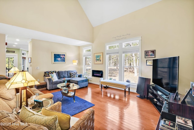 living room with hardwood / wood-style flooring, baseboards, high vaulted ceiling, and recessed lighting