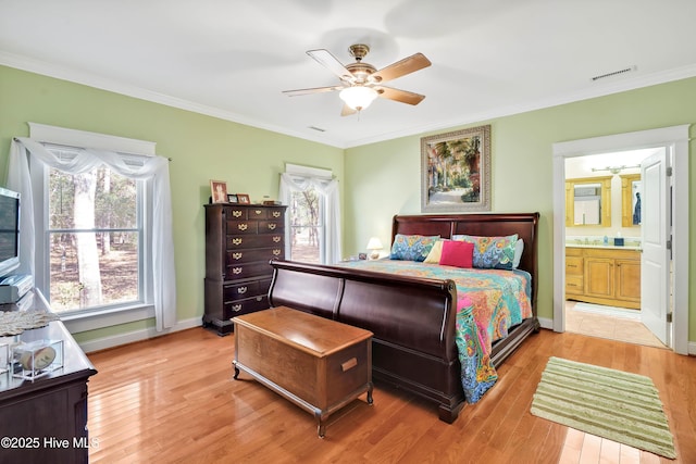 bedroom with light wood-style floors, ornamental molding, and baseboards