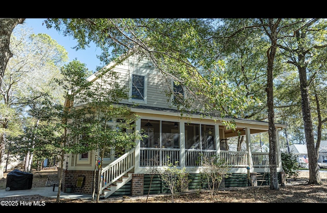 back of house with a sunroom and stairs
