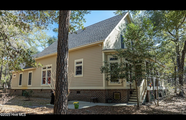 view of property exterior with a shingled roof and crawl space