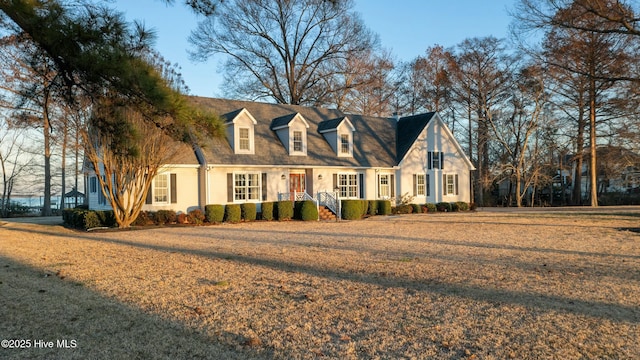 cape cod home featuring a front yard