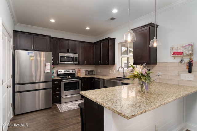 kitchen featuring stainless steel appliances, a peninsula, a sink, visible vents, and dark brown cabinets