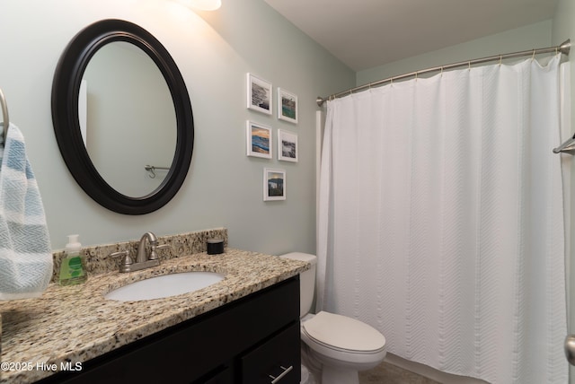 bathroom featuring curtained shower, vanity, and toilet