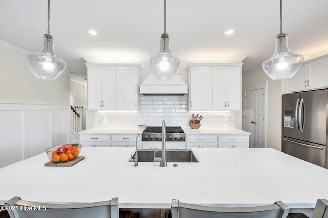 1066 Bradshaw Ter, Wilmington, NC 28412 - kitchen with a sink, a kitchen breakfast bar, a kitchen island with sink, stainless steel fridge, and light countertops