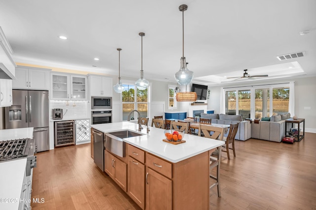 1066 Bradshaw Ter, Wilmington, NC 28412 - kitchen with a sink, wine cooler, a breakfast bar area, a tray ceiling, and appliances with stainless steel finishes