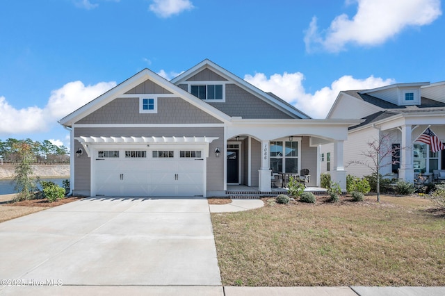 craftsman inspired home featuring concrete driveway, covered porch, a front yard, and a garage