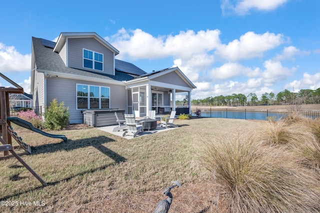 1066 Bradshaw Ter, Wilmington, NC 28412 - back of house featuring a hot tub, roof with shingles, a patio, roof mounted solar panels, and a sunroom