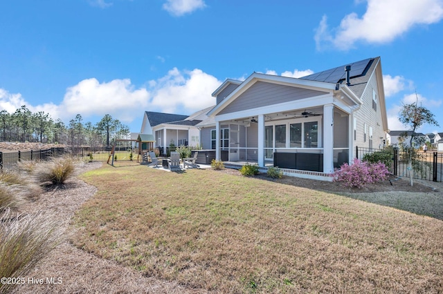 1066 Bradshaw Ter, Wilmington, NC 28412 - back of property featuring a yard, a fenced backyard, ceiling fan, solar panels, and a sunroom