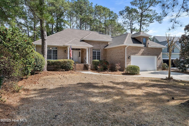 ranch-style home with a garage, driveway, brick siding, and a shingled roof