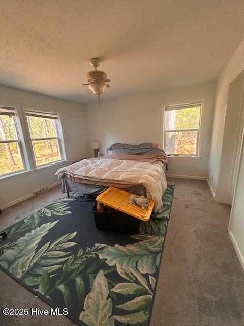 bedroom with carpet, baseboards, ceiling fan, and a textured ceiling