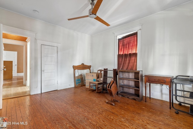 living area featuring wood-type flooring and a ceiling fan