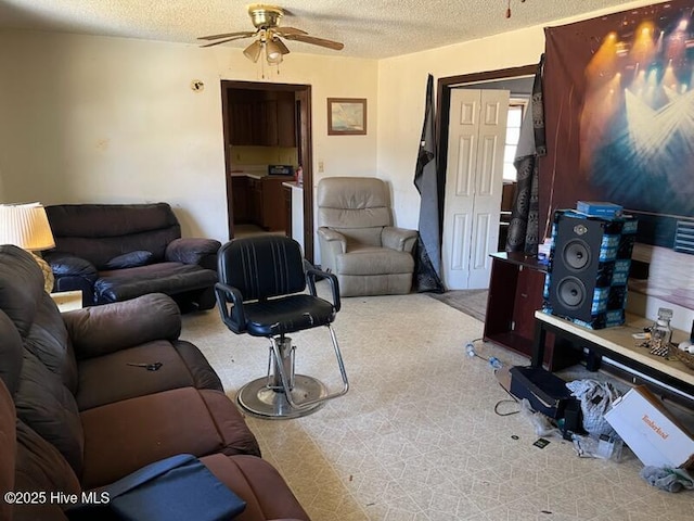 living room featuring a ceiling fan, light colored carpet, and a textured ceiling