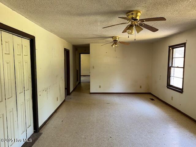 350 Randolphville Rd NE, Bolivia, NC 28422 - spare room with baseboards, a textured ceiling, ceiling fan, and light floors