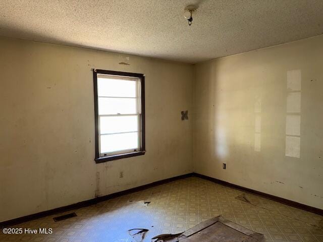 350 Randolphville Rd NE, Bolivia, NC 28422 - spare room with a textured ceiling, tile patterned floors, and visible vents