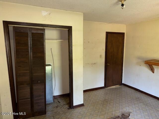 350 Randolphville Rd NE, Bolivia, NC 28422 - unfurnished bedroom with a closet, a textured ceiling, and baseboards