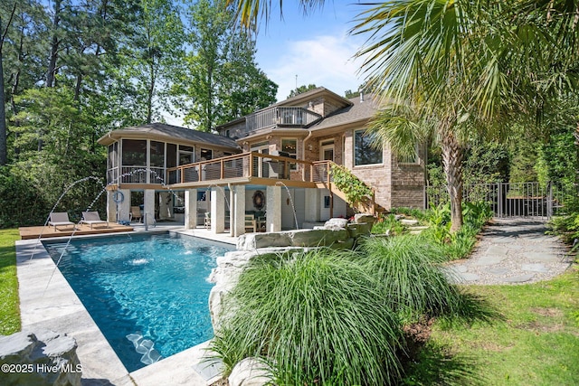 back of property with brick siding, a sunroom, stairway, a balcony, and a patio