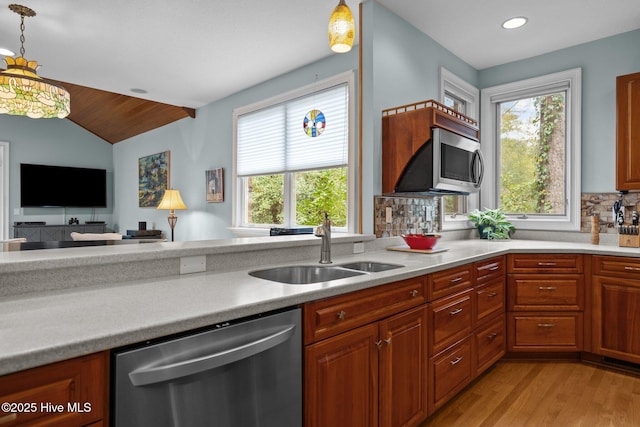 kitchen featuring a sink, pendant lighting, appliances with stainless steel finishes, and light countertops