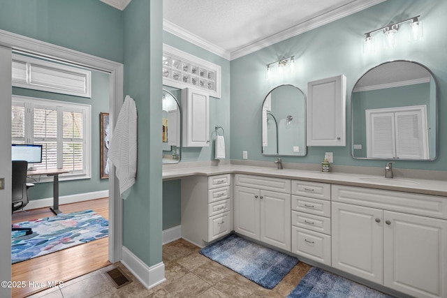 bathroom featuring a sink, ornamental molding, and double vanity