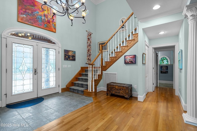 foyer with french doors, visible vents, wood finished floors, stairway, and a chandelier