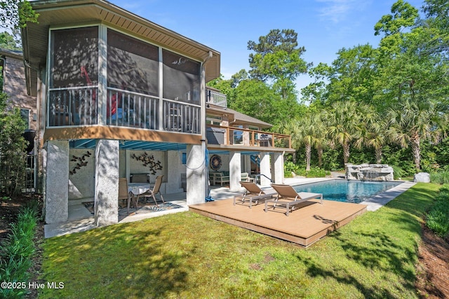 back of house with a yard, a deck, an outdoor pool, and a patio area