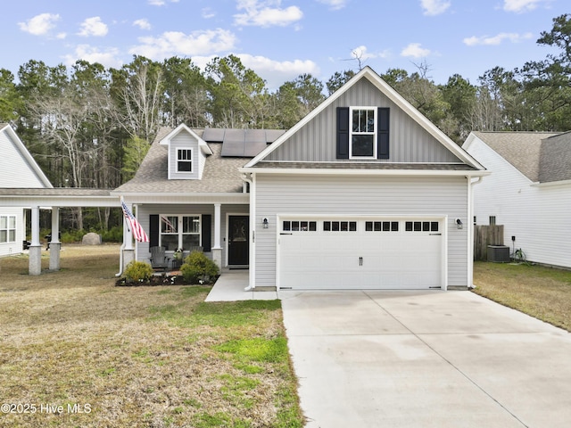 view of front facade featuring board and batten siding, a front lawn, concrete driveway, and covered porch