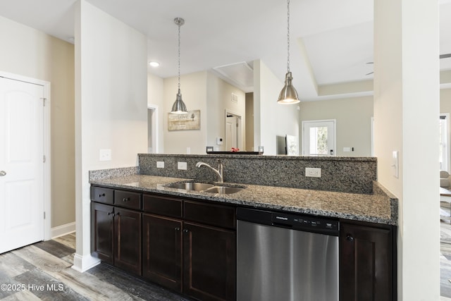 kitchen with a sink, stone countertops, stainless steel dishwasher, and light wood finished floors