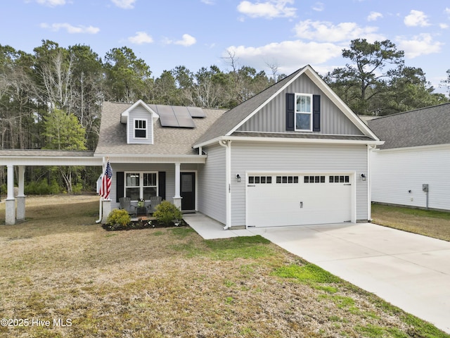 view of front of house with driveway, board and batten siding, covered porch, a front yard, and solar panels