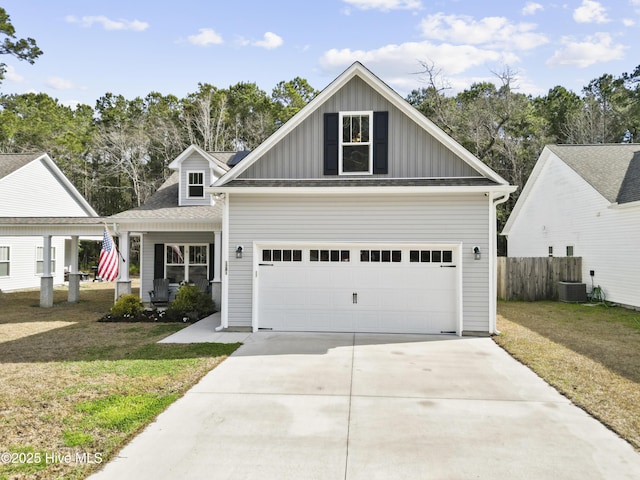 view of front of house with a front yard, central AC unit, fence, driveway, and board and batten siding