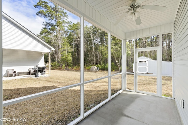 unfurnished sunroom featuring ceiling fan