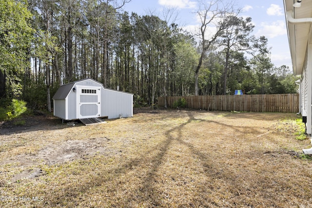 view of yard featuring an outbuilding, fence, and a shed