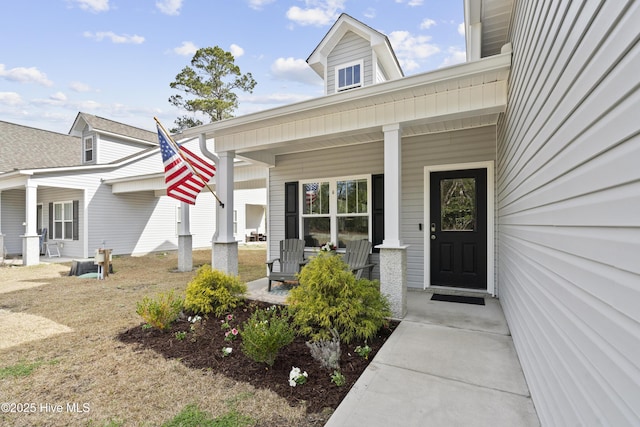 view of exterior entry featuring covered porch