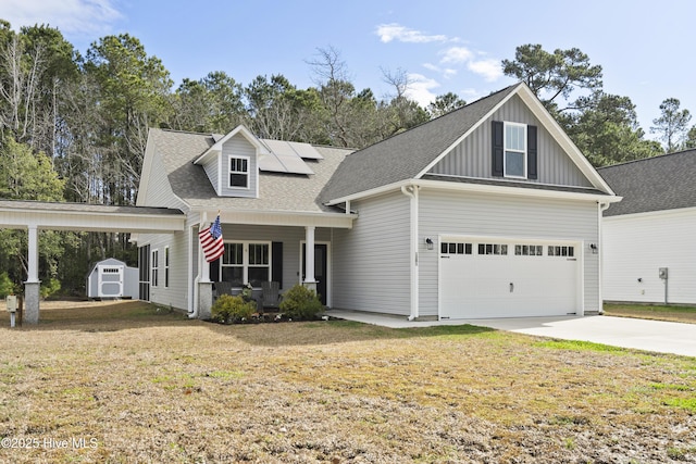 view of front facade with driveway, a front lawn, a porch, a storage shed, and solar panels