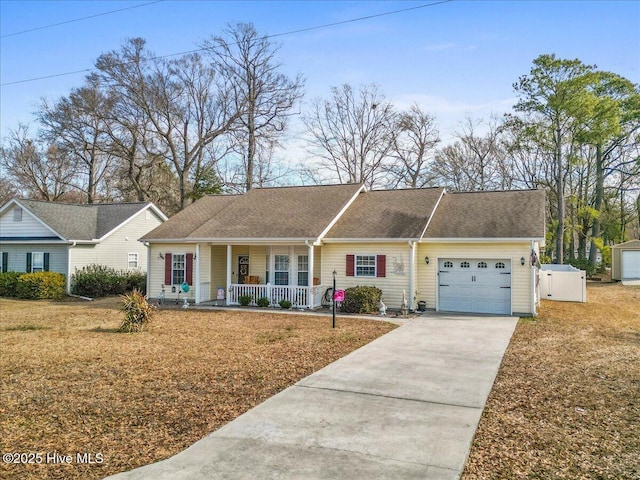 ranch-style home featuring covered porch, driveway, an attached garage, and a front yard