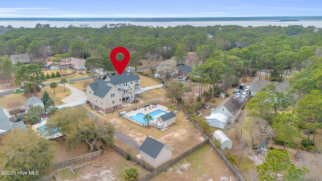 birds eye view of property featuring a forest view and a water view