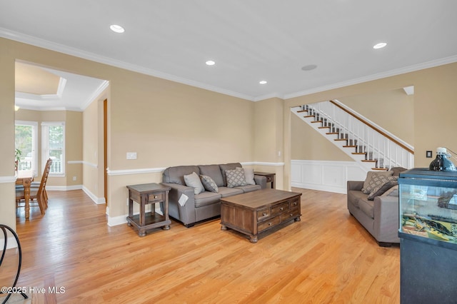 living room featuring light wood finished floors, stairway, ornamental molding, recessed lighting, and a wainscoted wall