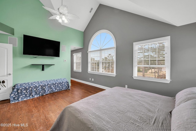 bedroom with high vaulted ceiling, wood finished floors, baseboards, and a ceiling fan