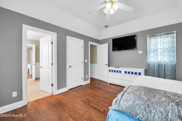 bedroom with vaulted ceiling, wood finished floors, baseboards, and ceiling fan