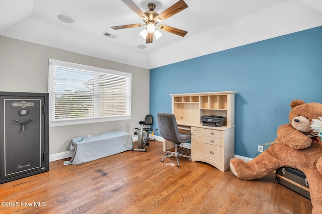 office space featuring visible vents, baseboards, ceiling fan, light wood-type flooring, and lofted ceiling