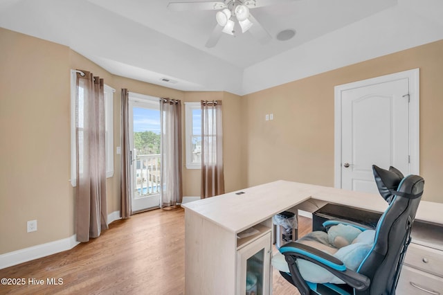 office area with light wood-style flooring, a ceiling fan, and baseboards