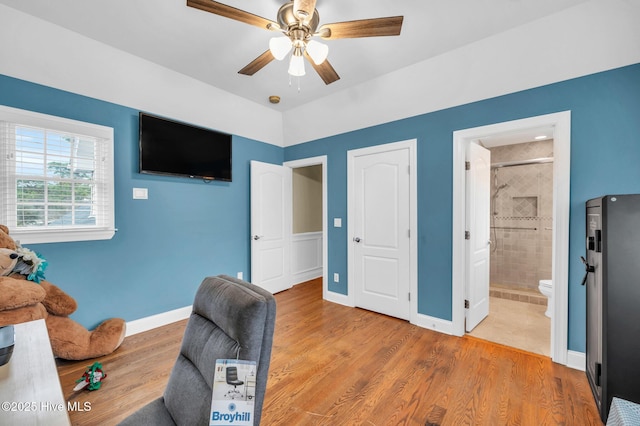 home office with a ceiling fan, wood finished floors, and baseboards