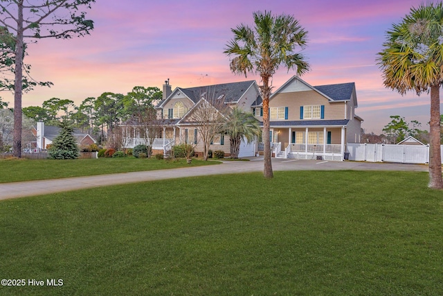 view of front of home featuring a front yard, a gate, fence, and covered porch