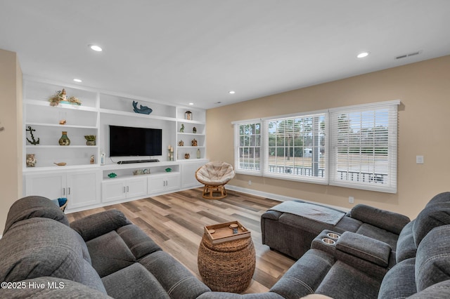 living area with recessed lighting, visible vents, and light wood finished floors