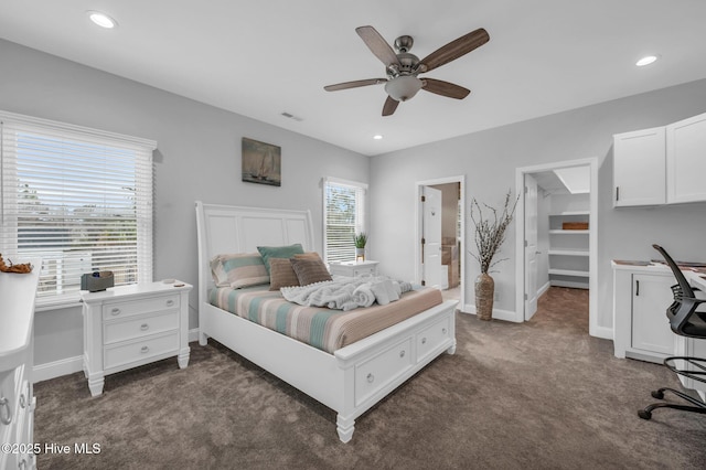 carpeted bedroom featuring a spacious closet, baseboards, recessed lighting, a desk, and a ceiling fan