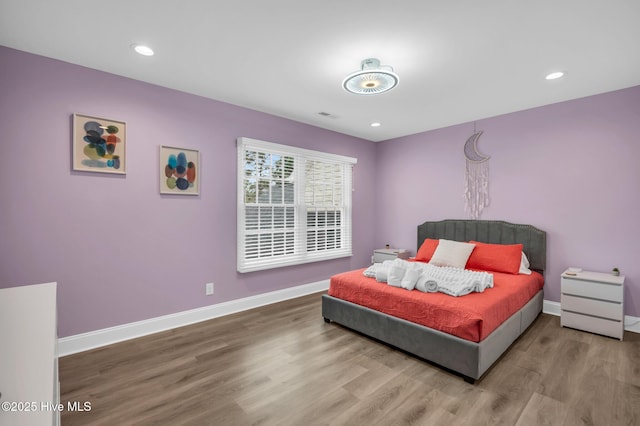 bedroom with wood finished floors, baseboards, and recessed lighting