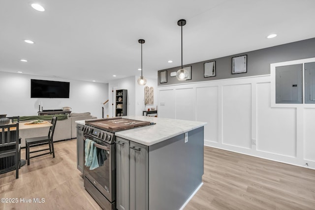 kitchen with light wood finished floors, a center island, a decorative wall, electric panel, and electric range