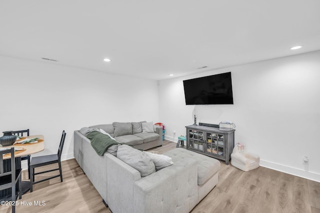 living room with recessed lighting, baseboards, and wood finished floors